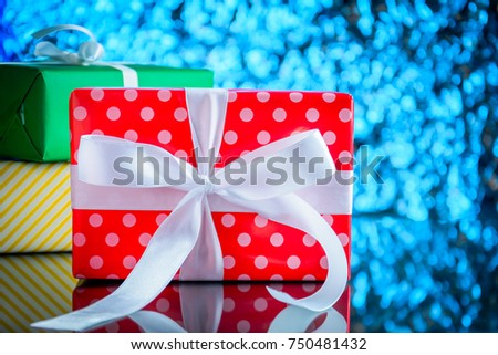 gifts and toys on glass table and bokeh blue light background with Christmas holidays and happy smile kids.selective focus