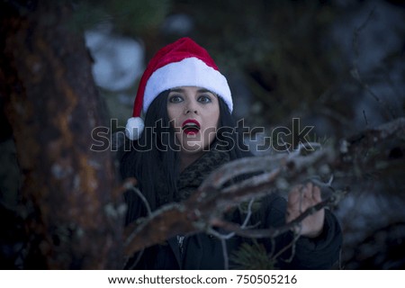 Pretty girl with santa claus hat. Snowy mountain.