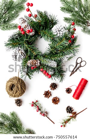 Make christmas wreath. Spruce branches, cones, threads, sciccors on white background top view
