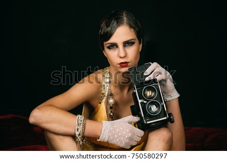 Girl with vintage photo camera. Pin up pretty fashion model photographer. Woman with retro hair, makeup and old camera. beauty, retro look, pinup fashion. media and new technology, journalism.