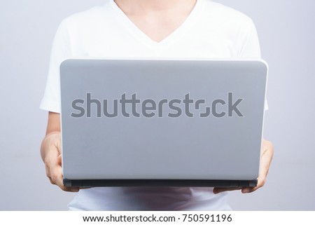 Woman holding laptop on grey background