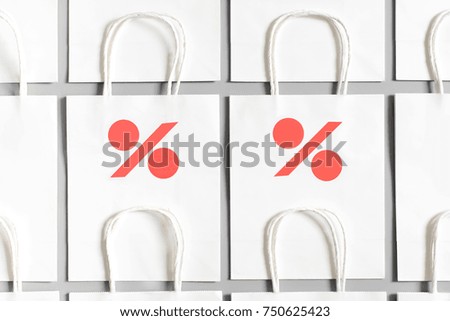 White shopping bags from recycle paper with percent sign on gray background. Black friday or Christmas sales.
