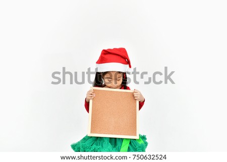 Little girl celebrates Christmas with red Santa dress.
