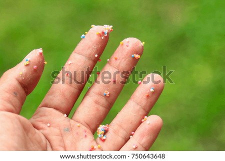 Dirty hand with colorful icing with green background 