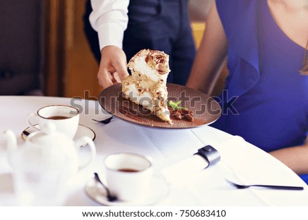 Picture showing waiter serving meringue cake