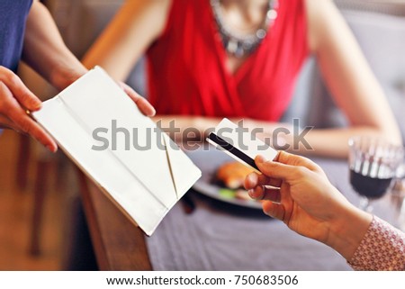 Picture showing people paying in restaurant by credit card reader