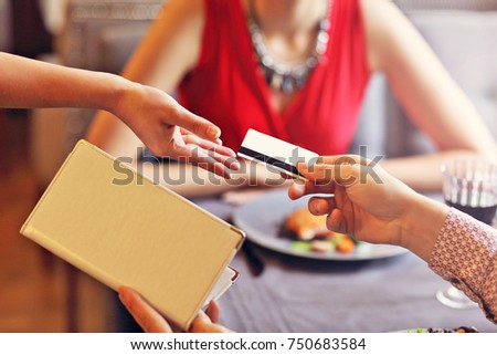 Picture showing people paying in restaurant by credit card reader