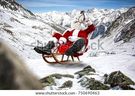 Santa Claus goes sledging. Beautiful winter alpine landscape. Blurry rocks in the foreground.