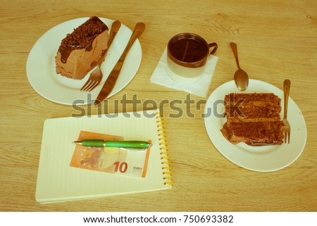 Tasty cake and coffee on wooden table. Cake, notepad, money and coffee - Retro color
