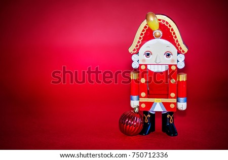 Nutcracker with ornament on red background