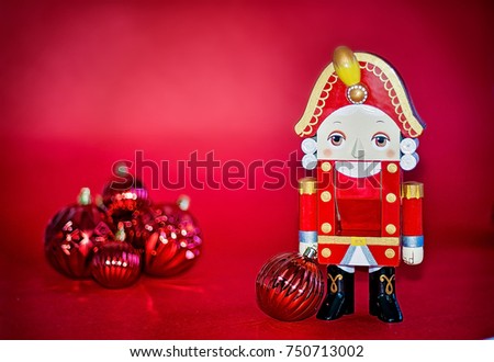 Nutcracker on red background with christmas ornaments