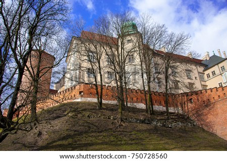 Wawel Castle, Krakow, Poland perches high on a hill. View to battlements, the residence and two of the towers with bright blue sky background