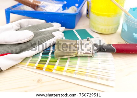Color palette guide and painting supplies, paint brushes and color cans on wooden background