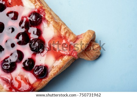 french pastry, dessert with tender vanilla cream and fruits, cake on blue background, close up