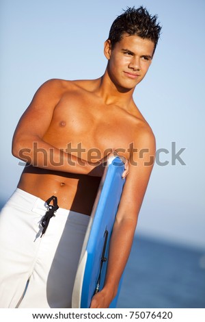 Young man at the beach with a boogie board