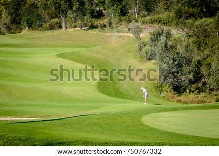 Woman golfer in Green landscape in golf club
