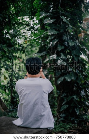 Asian hipster man using camera for taking photo with green forest background