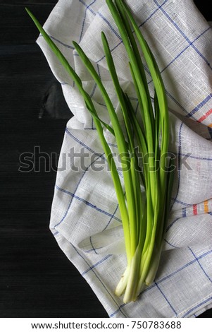 
green onions and linen on the dark, the concept of cooking at home