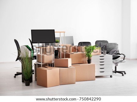 Carton boxes with stuff in empty room. Office move concept Royalty-Free Stock Photo #750842290