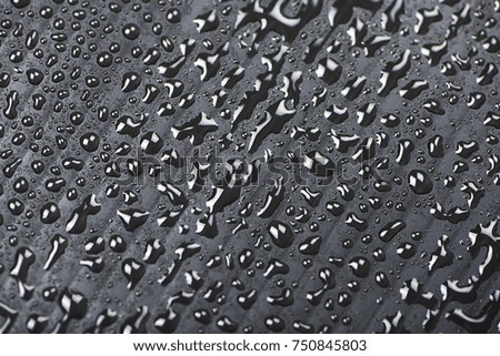 Abstract background of water droplets on black surface.