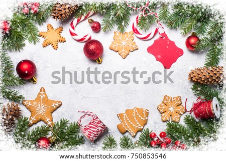 Christmas frame background. Christmas gingerbread with xmas decorations on gray stone table. Top view with copy space. Snow frame effect.