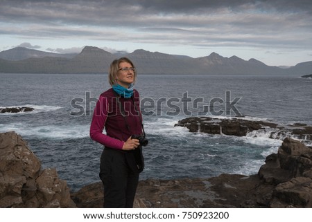 woman photographer looking for a subject on the cliffs of the faroe islands