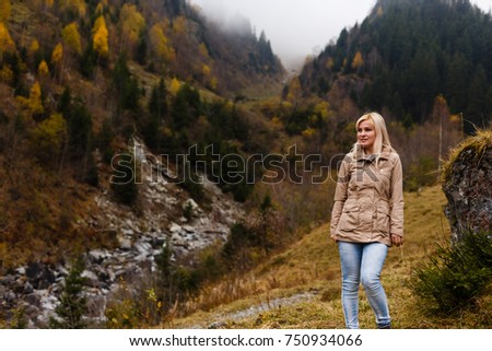 Girl travel in mountains alone. Spring weather, calm scene. Backpacker walking outdoors, back view over landscape. Wanderlust photo series.