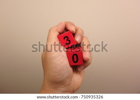 Hand holding number 30 red cube box in hand