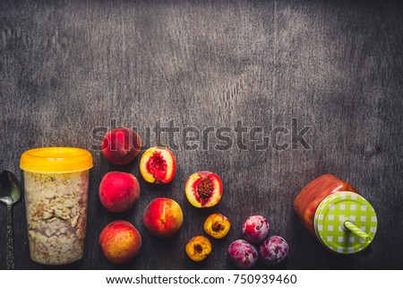 Useful peach fruit smoothie in glass bottle and straws and oatmeal with fruits, vegetarian breakfasts