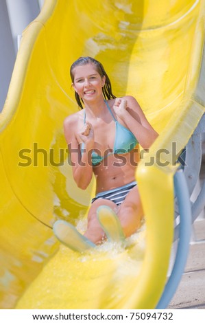 Happy summer vacation - young girl sliding to the water