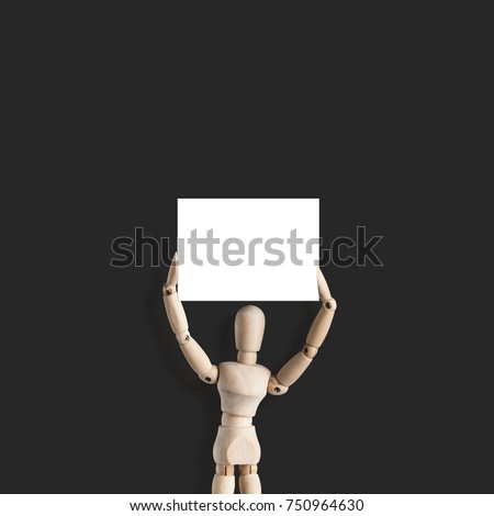 Wooden mannequin holds blank sign or billboard. Concept for advertising or protest board on revolution