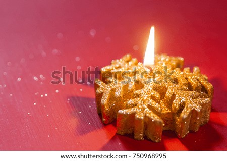 Burning candles in Christmas setting. Christmas Candle, shining candles with christmas decorations. burning candles, against red background. Christmas candle burning bright , copy space 