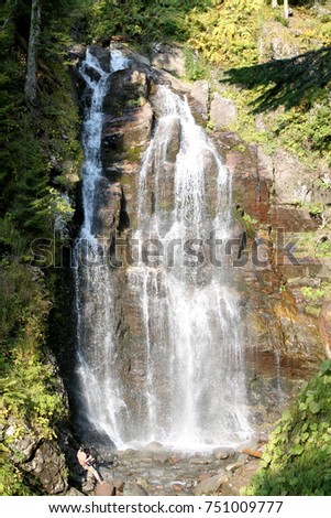 Photo of a beautiful big waterfall lit by the sun
