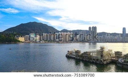 Hong Kong Island across the harbour with a factory site by the seaside at foreground