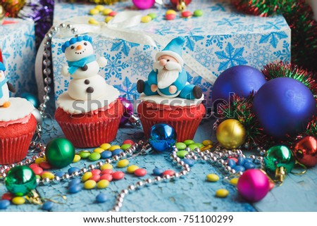 Christmas cupcakes with decorations made from confectionery mastic, soft focus background
