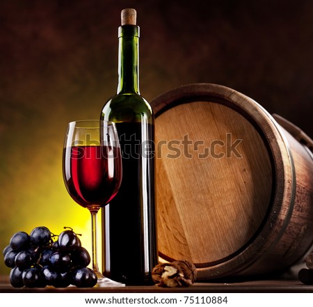 Still life with wine bottle, glass and oak barrels.