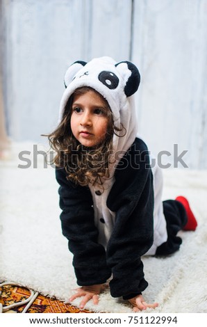 a little girl dressed in a bear costume Panda. 