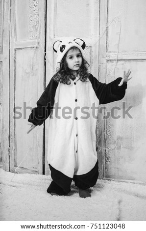 a little girl dressed in a bear costume Panda. 