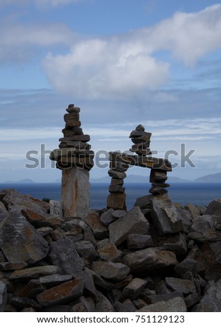 Landscape picture of two human-made piles (or stacks) of stones called a cairn captured in Ireland