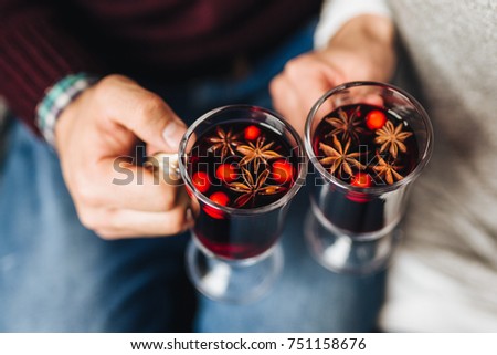 Crop people clinking with glasses full of mulled wine withs spices.  Royalty-Free Stock Photo #751158676