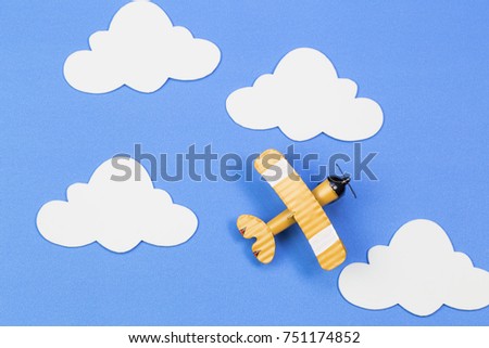 toy airplane on a background of blue sky with paper clouds. The concept travel and airlines 