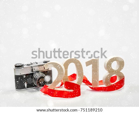 Figures 2018 carved from wood with a vintage camera. Concept of a New Year's postcard, poster. Photo Trends