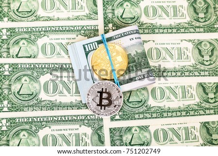 Folded american dollars and coins of cryptocurrency over dollar banknotes. Business concept