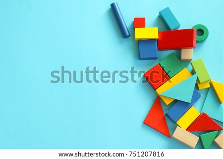 Pile of colorful toy blocks on blue background.