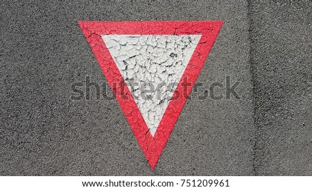 Inverted white with red border triangular road sign yield that you need to wait and give other cars the right to pass