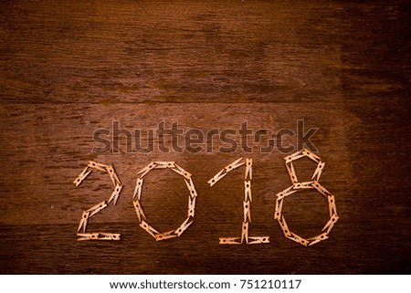 Happy new year 2018 text on papers with clothespins on wooden background, year of the dog