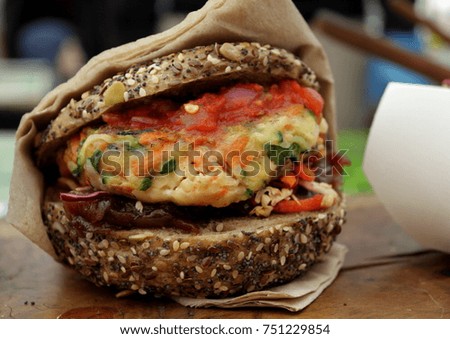 Closeup landscape picture of a vegetarian burger wrapped in a napkin at a fair in London, United Kingdom