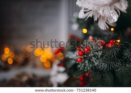 Original decor and toys hangs on rich Christmas tree standing in a cosy room