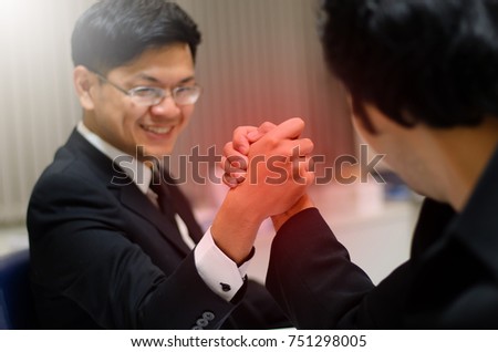 Concept: business competition, two businessmen's competitive sports arm wrestling