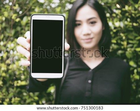 Asian white girl show a blank screen mobile phone to show.This picture is a mock up to edit with a Advertising. 